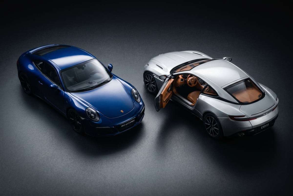 Close-up of a sealed one-piece resin model body next to a diecast model with an open door and visible interior